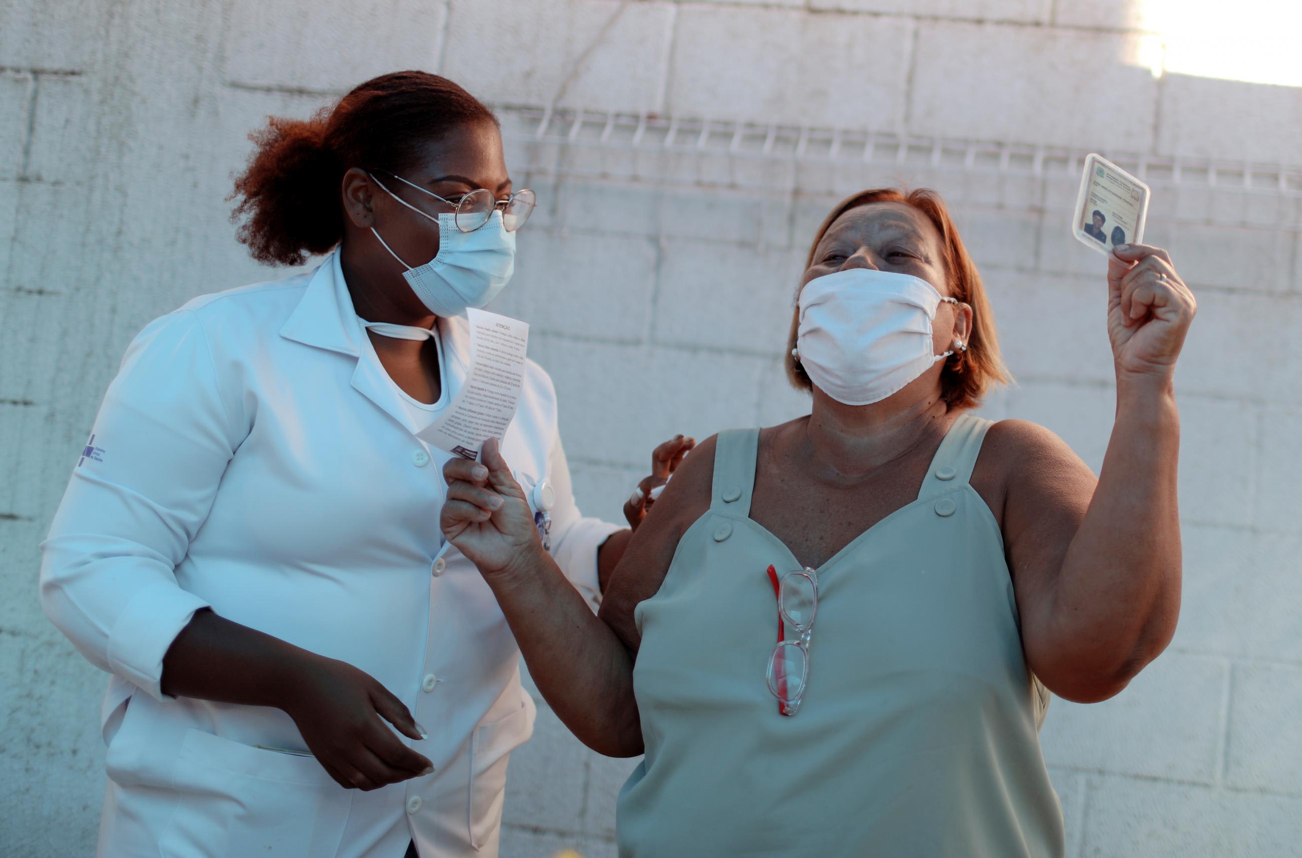 A health-care worker shows a vaccination card after receiving a dose of the AstraZeneca/Oxford coronavirus disease vaccine at a public hospital in Rio de Janeiro, Brazil on January 27, 2021.