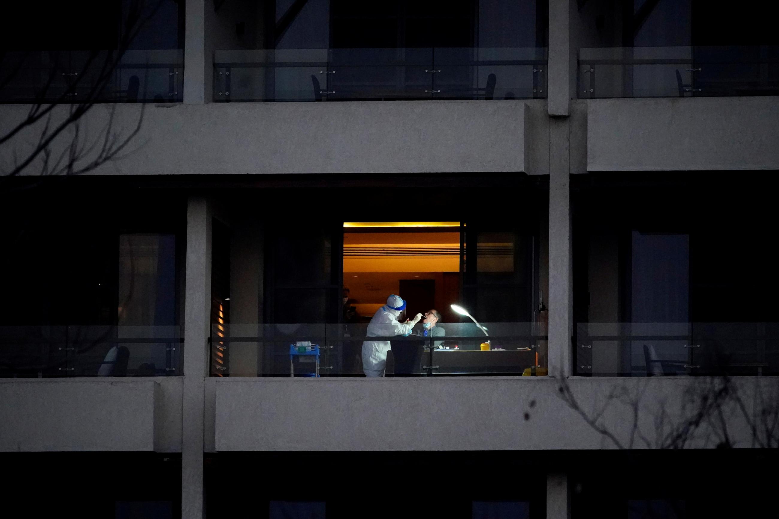 WHO virus expert Peter Ben Embarek, a member of the World Health Organisation (WHO) team tasked with investigating the origins of the coronavirus disease (COVID-19), receives a swab test on the balcony of a hotel in Wuhan, Hubei province, China February 3, 2021.