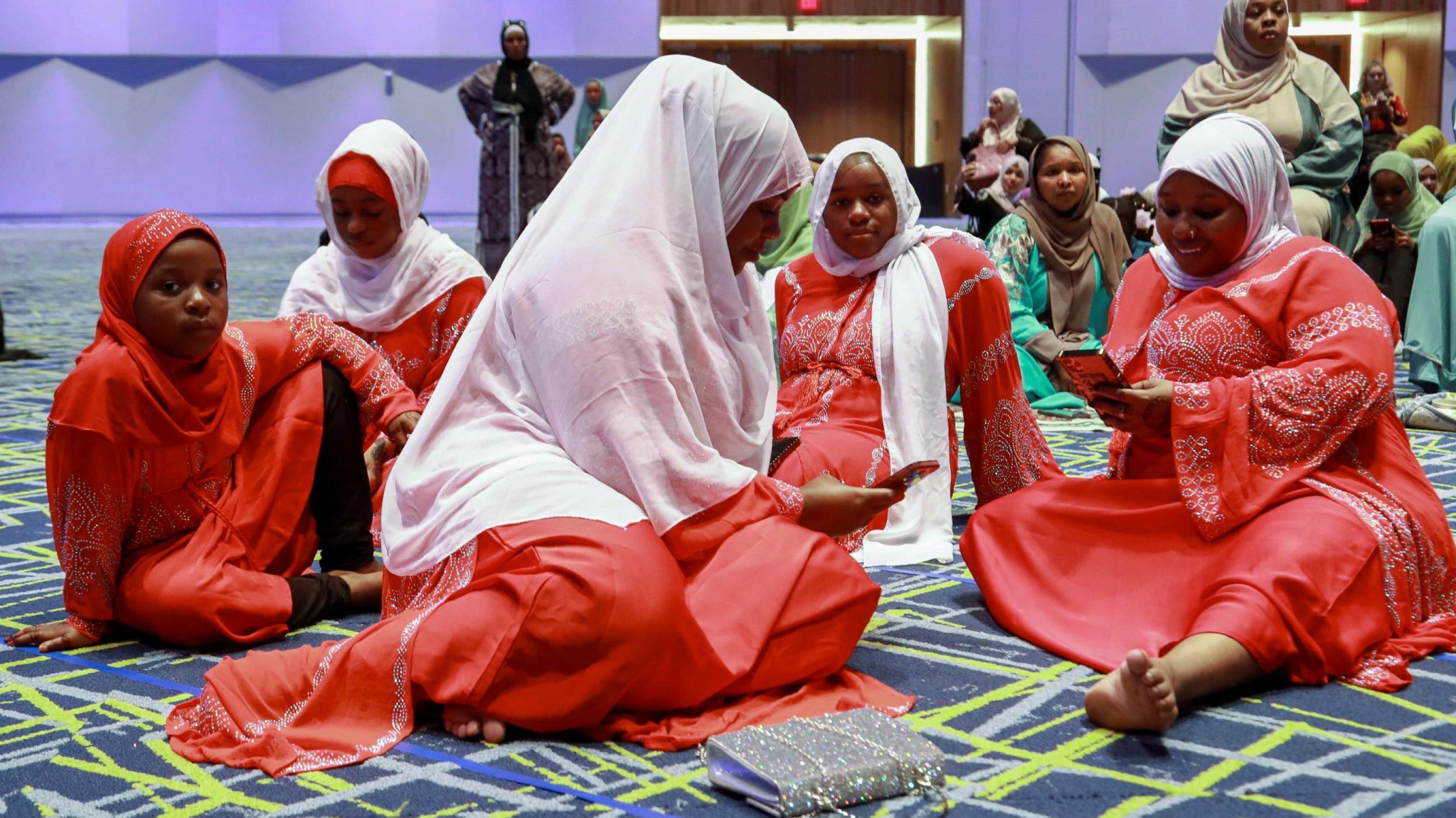 The Alis, an immigrant family from Kenya, sit together on the floor, gathering with the Muslim community at Kentucky International Convention Center to celebrate the Eid al-Adha festival, in Louisville, Kentucky, on July 9, 2022.