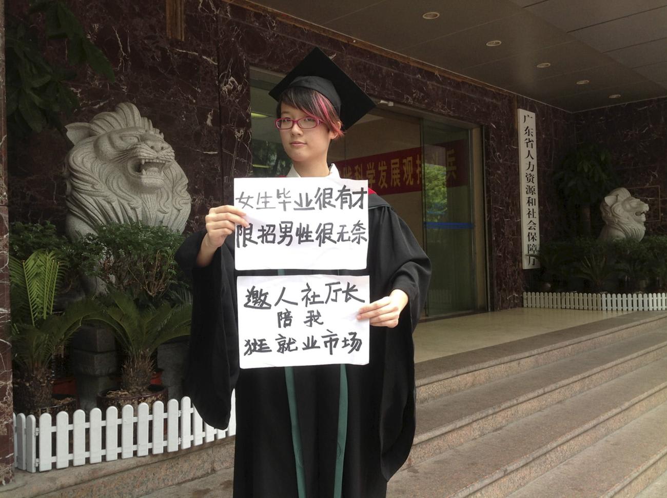 Women activist Zheng Churan, twenty-five, poses for a photograph with papers that read "Women graduates are talented, only hiring men is frustrating" (top) and "I invite the head of Human Resources and Social Security department to go to the job market with me", in this undated handout picture taken in an unknown location in China, provided by a women's rights group on April 8, 2015. The women were taken into custody on the weekend of International Women's Day, March 8, and later detained.