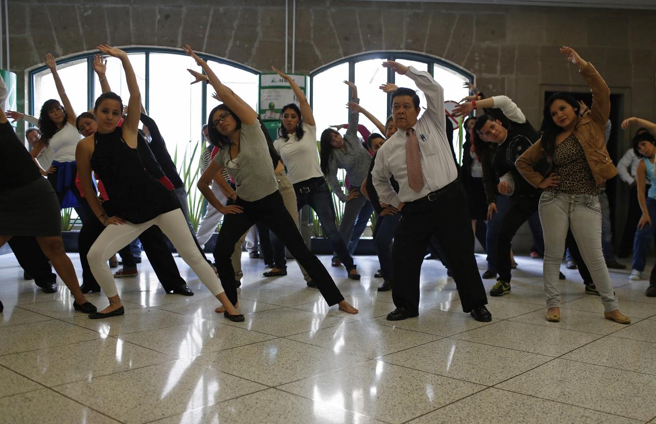 Government employees participate in a mandatory physical activity session, to counter obesity, at their office in downtown Mexico City, Mexico, on August 14, 2013.