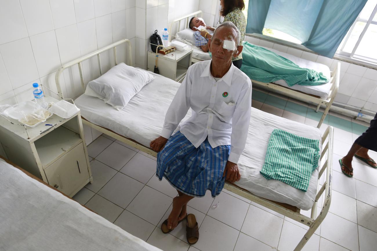 A man sits on a bed after going through free eye surgery at the Phyo charity clinic in Yangon September 4, 2014.