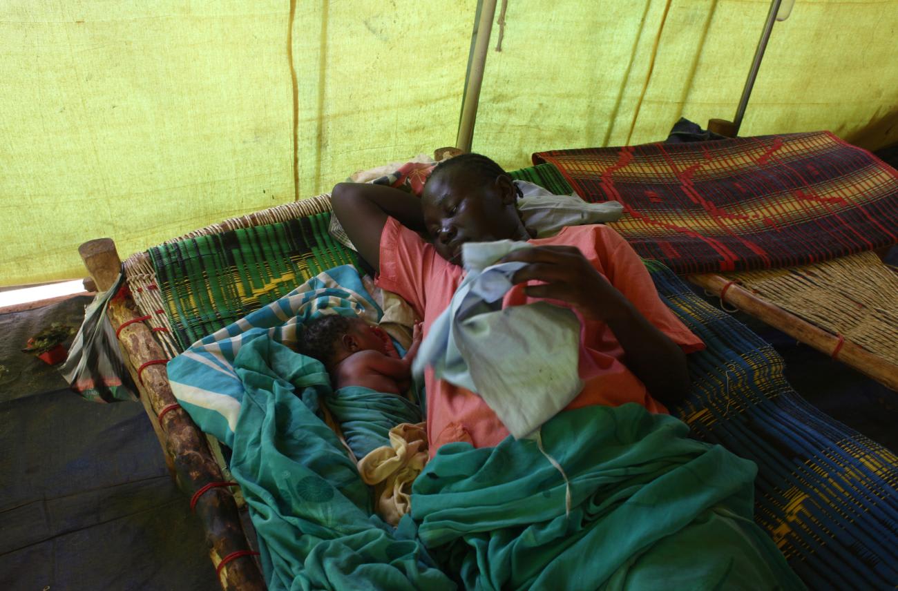 Rania Abdulai rests next to her newborn child at the maternity ward of the International Rescue Committee (IRC) clinic at Yida camp in Unity State, South Sudan, on April 20, 2013.