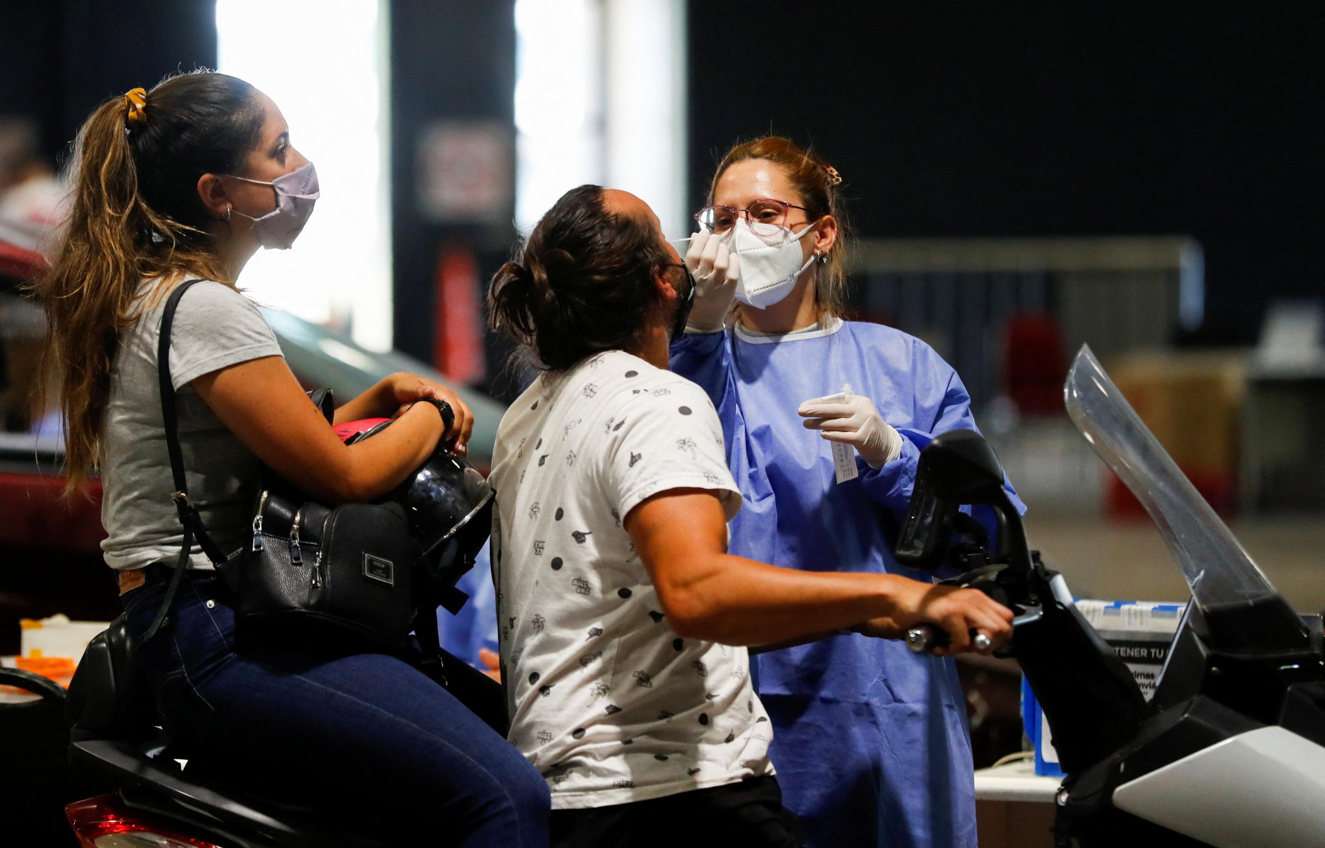 A health-care worker takes a swab sample from a man to be tested for the coronavirus disease (COVID-19), at La Rural, in Buenos Aires, Argentina December 23, 2021.