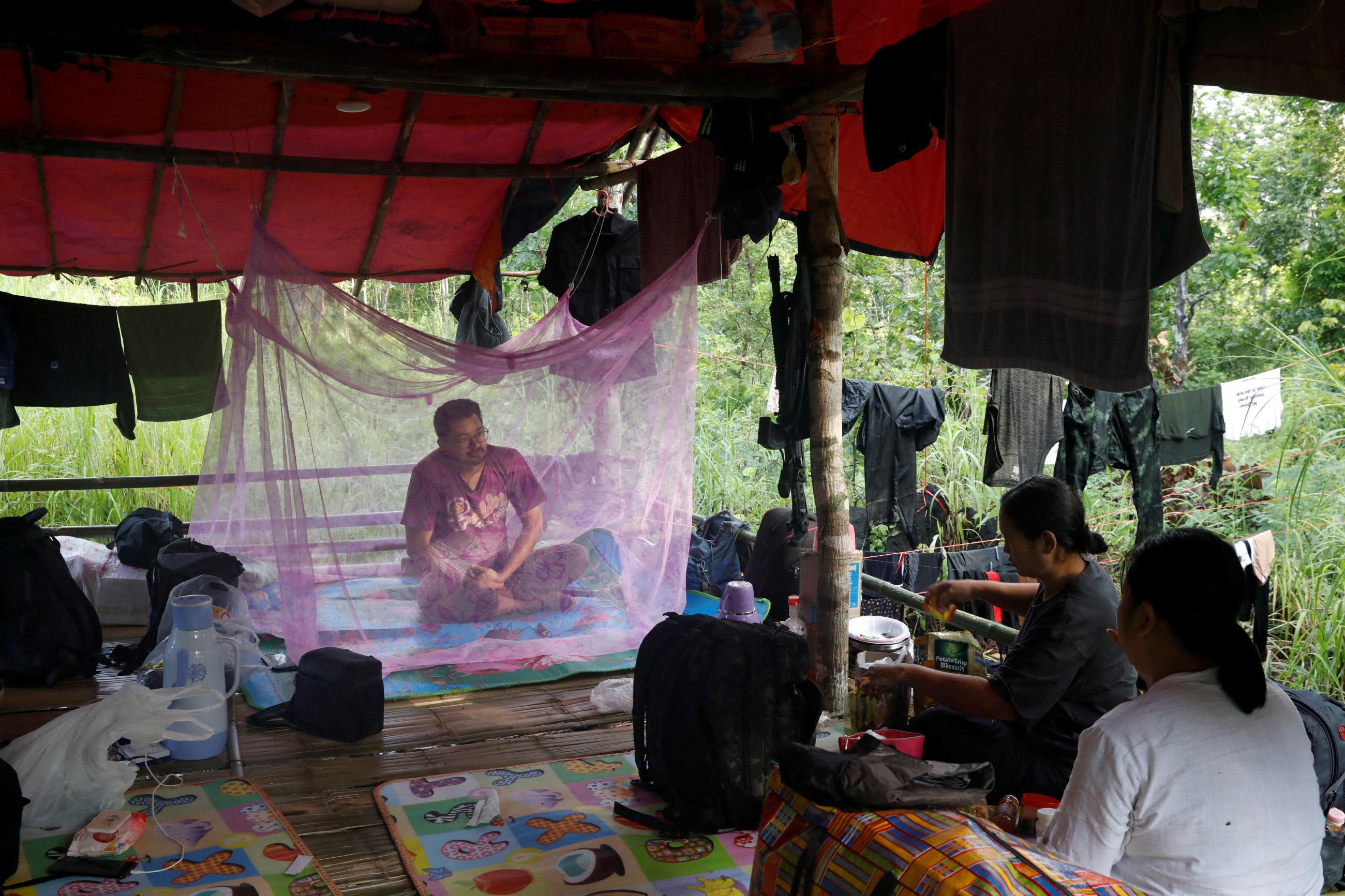 Sithu Maung, an elected member of parliament in the 2020 elections, sits under a mosquito net at a training camp in an area controlled by ethnic Karen rebels, Karen State, Myanmar, on September 13, 2021. REUTERS/Independent photographer