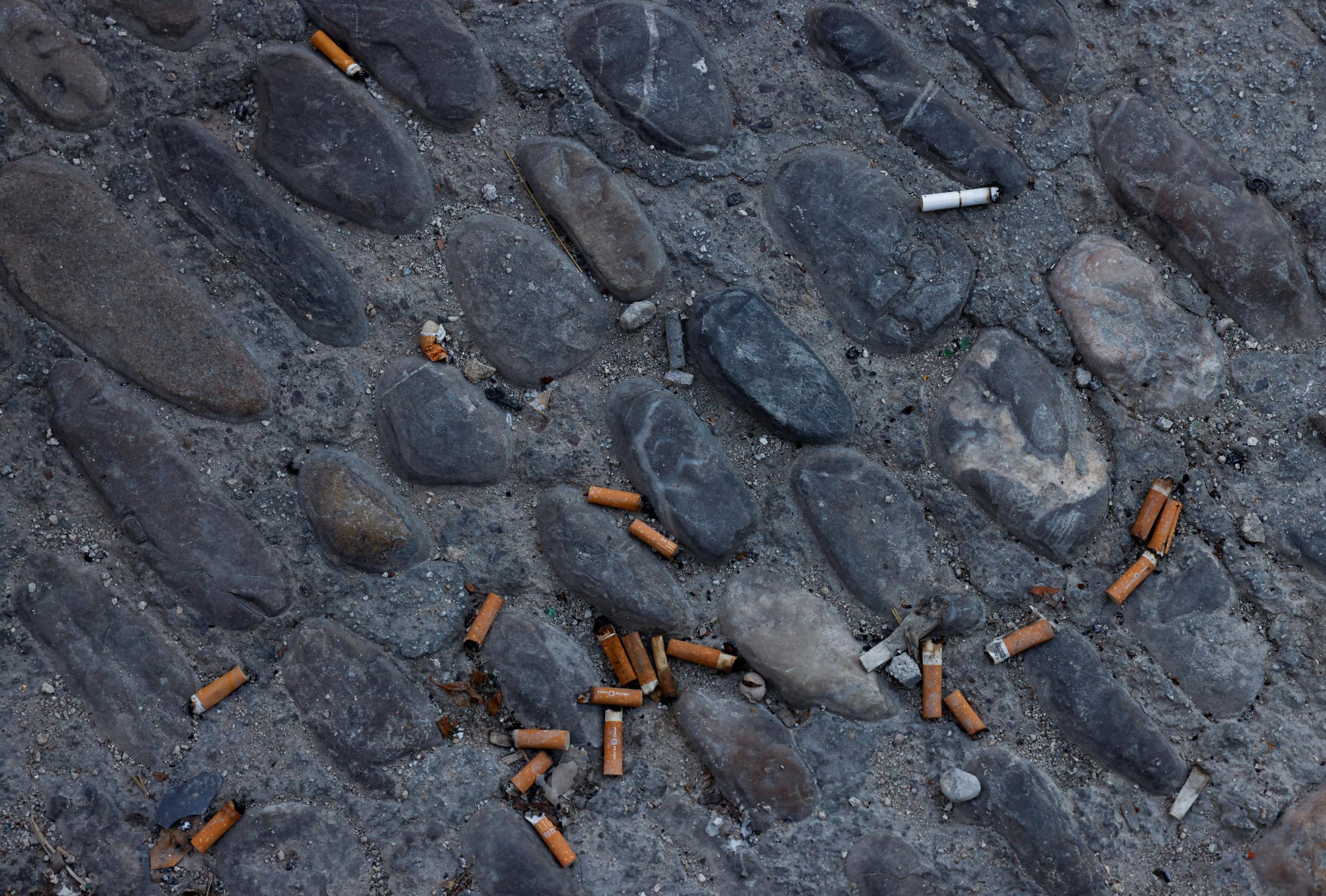 Cigarette butts are left on the floor outside a pub in Ronda, Spain, October 13, 2022.
