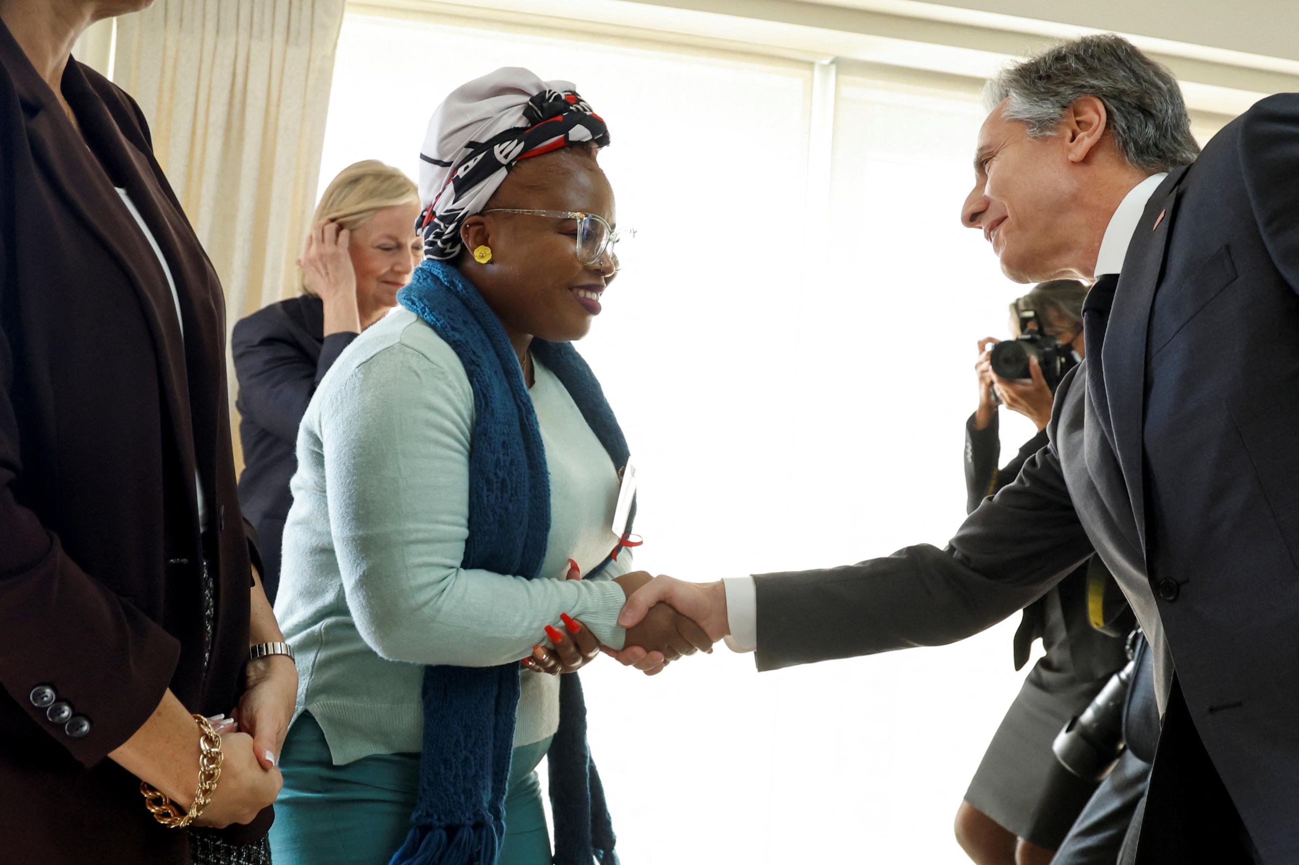 U.S. Secretary of State Anthony Blinken shakes hands with Elizabeth Glaser Pediatric AIDS Foundation ambassador Dee Mphafi after speaking to a World AIDS Day event hosted by the Business Council for International Understanding in Washington, DC.