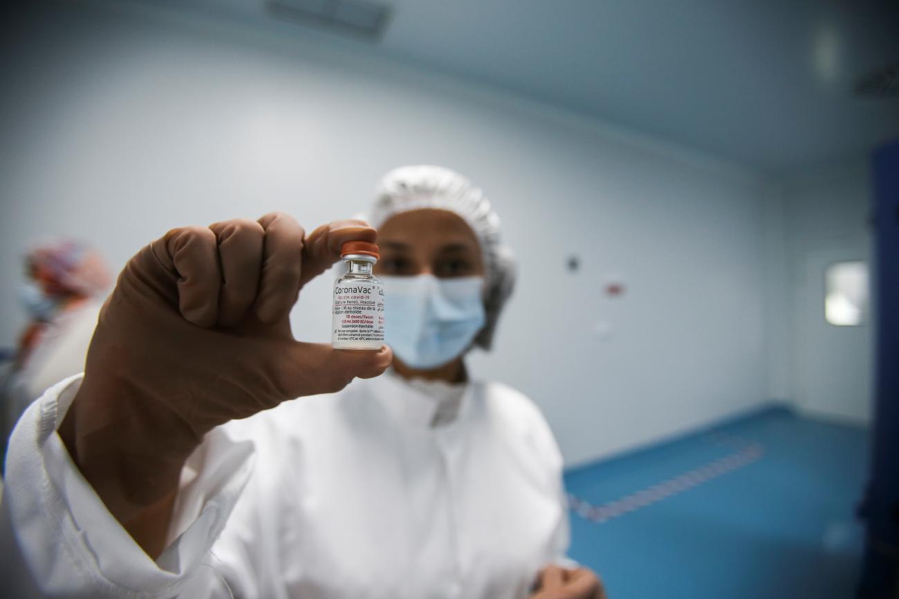 A lab technician holds a vial of CoronaVac vaccine during the inauguration of a production lab designated to manufacture the vaccine