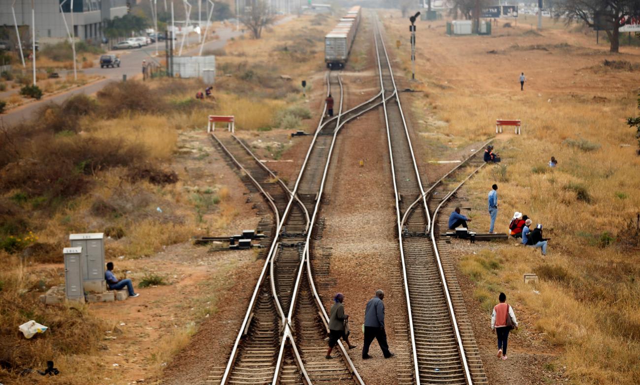 People cross rail tracks in the Central Business District