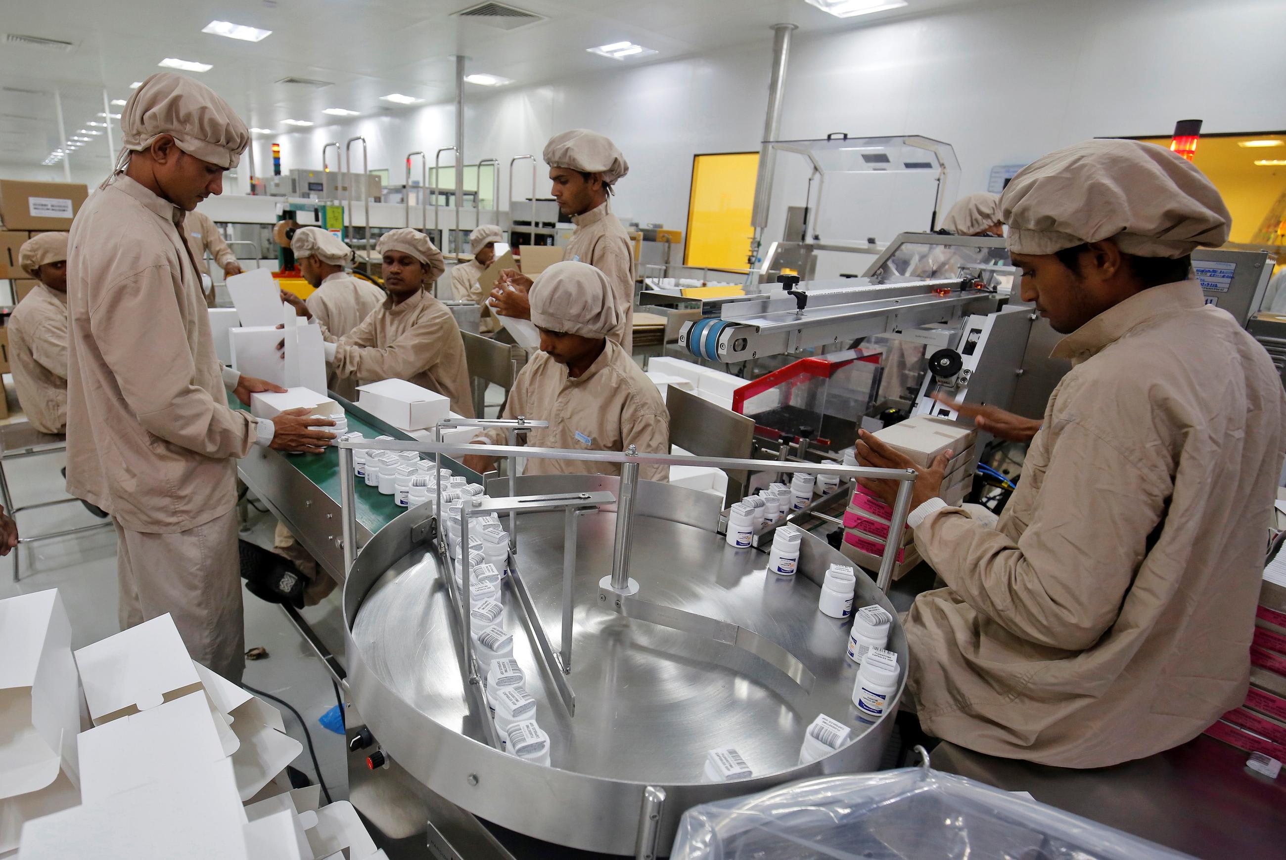 Workers pack medicine bottles inside Alembic Pharmaceutical Limited's plant.