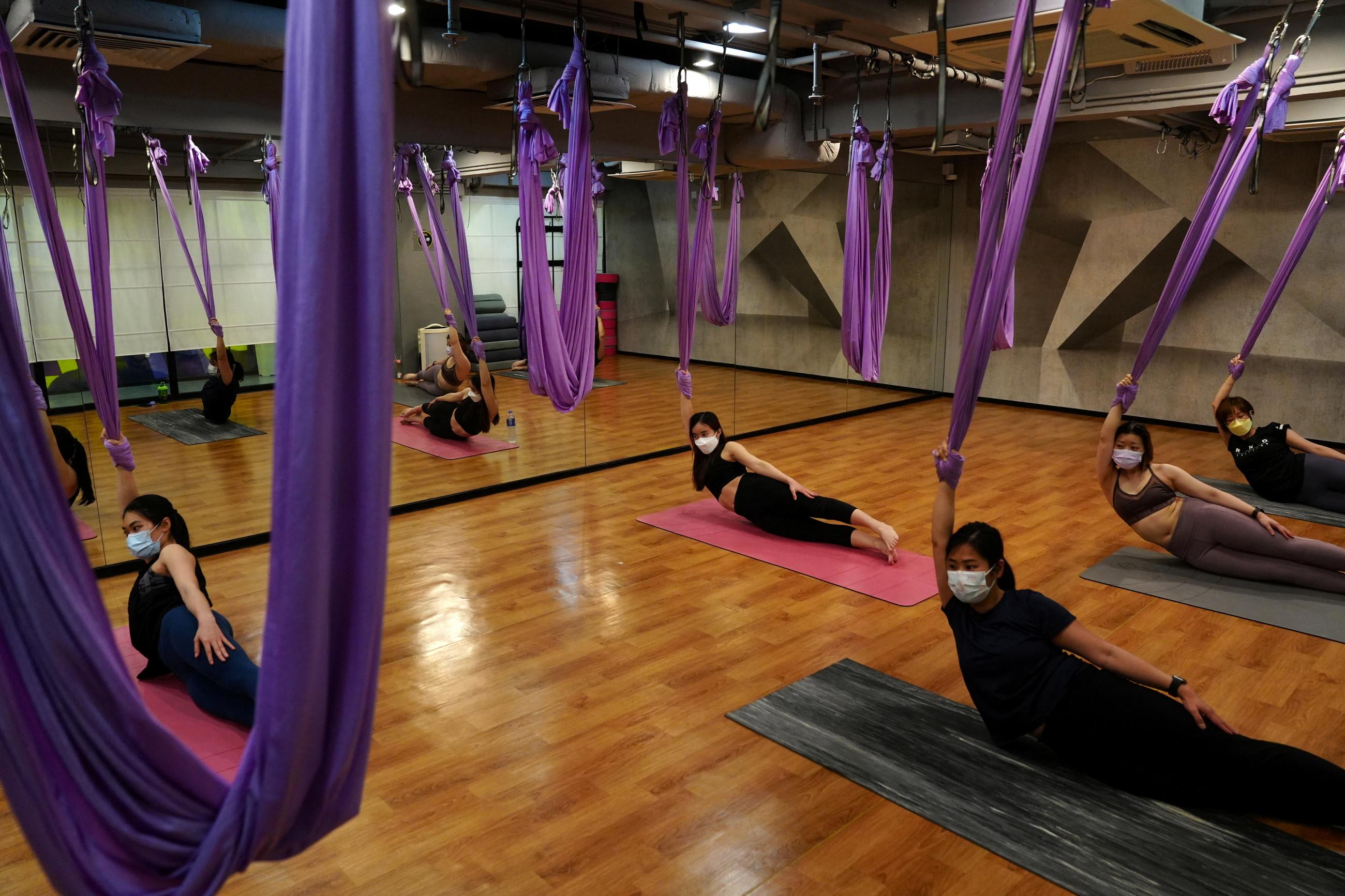 People wear face masks during a yoga class on the day of its reopening after the government eased COVID-19 business restrictions in Hong Kong, China, on April 21, 2022.