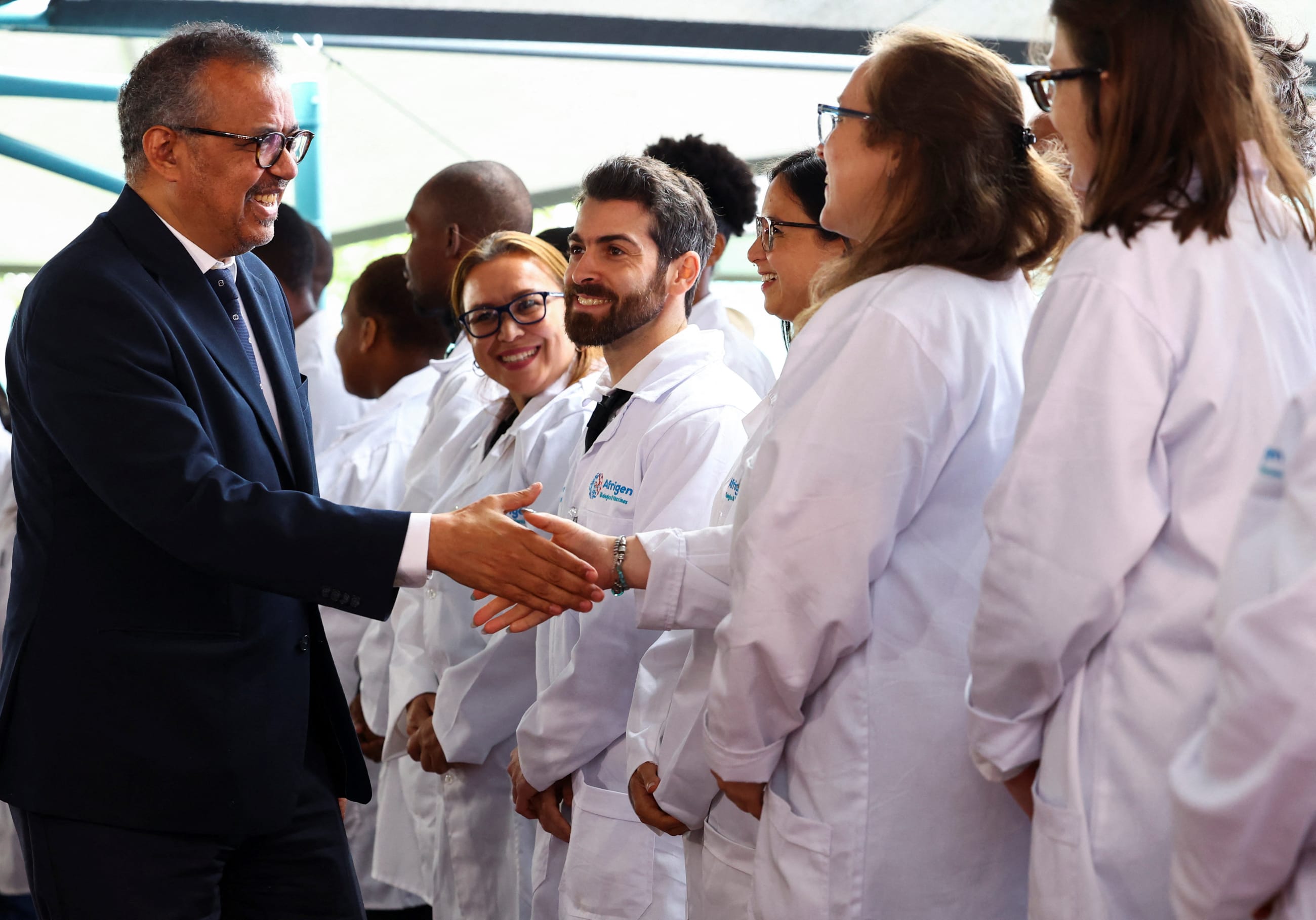The head of the World Health Organization (WHO), Dr Tedros Adhanom Ghebreyesus, greets staff members at the Afrigen Biologics facility, ahead of the launch of a WHO-backed mRNA vaccine production and technology transfer hub in Cape Town, South Africa, on April 20, 2023.