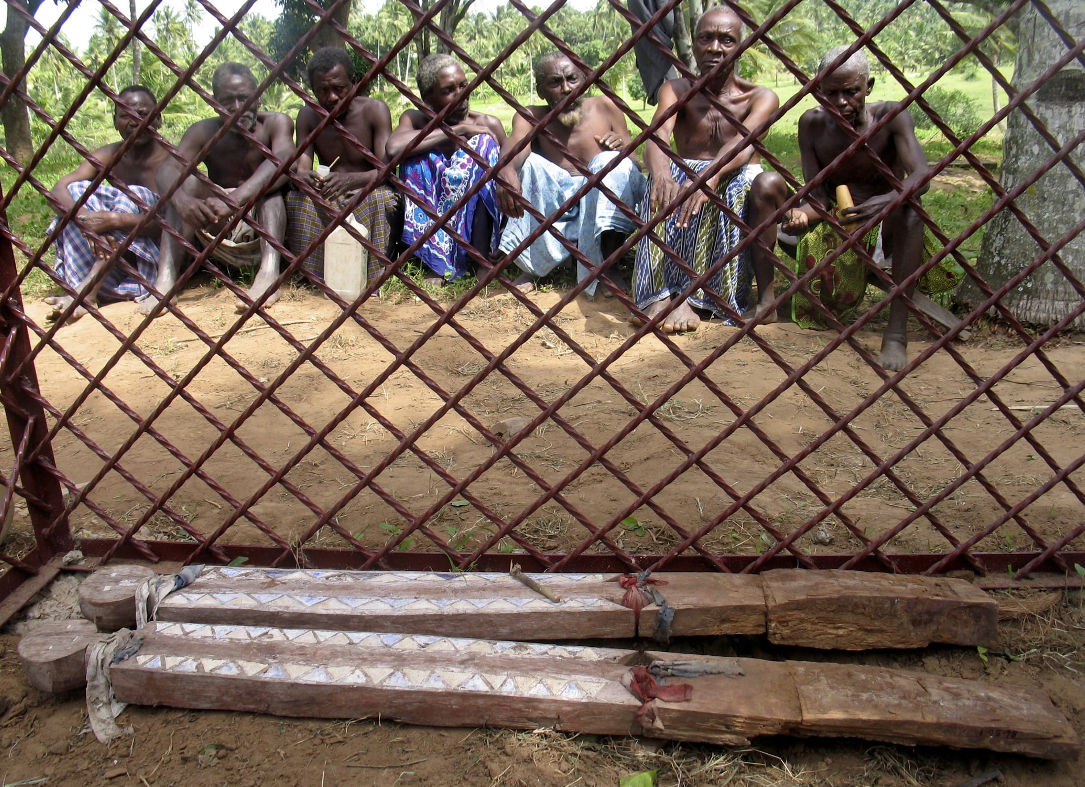 Traditional elders from the Giriama community guard two memorial statues, marking their return, in Mombasa, Kenya, on June 20, 2007.