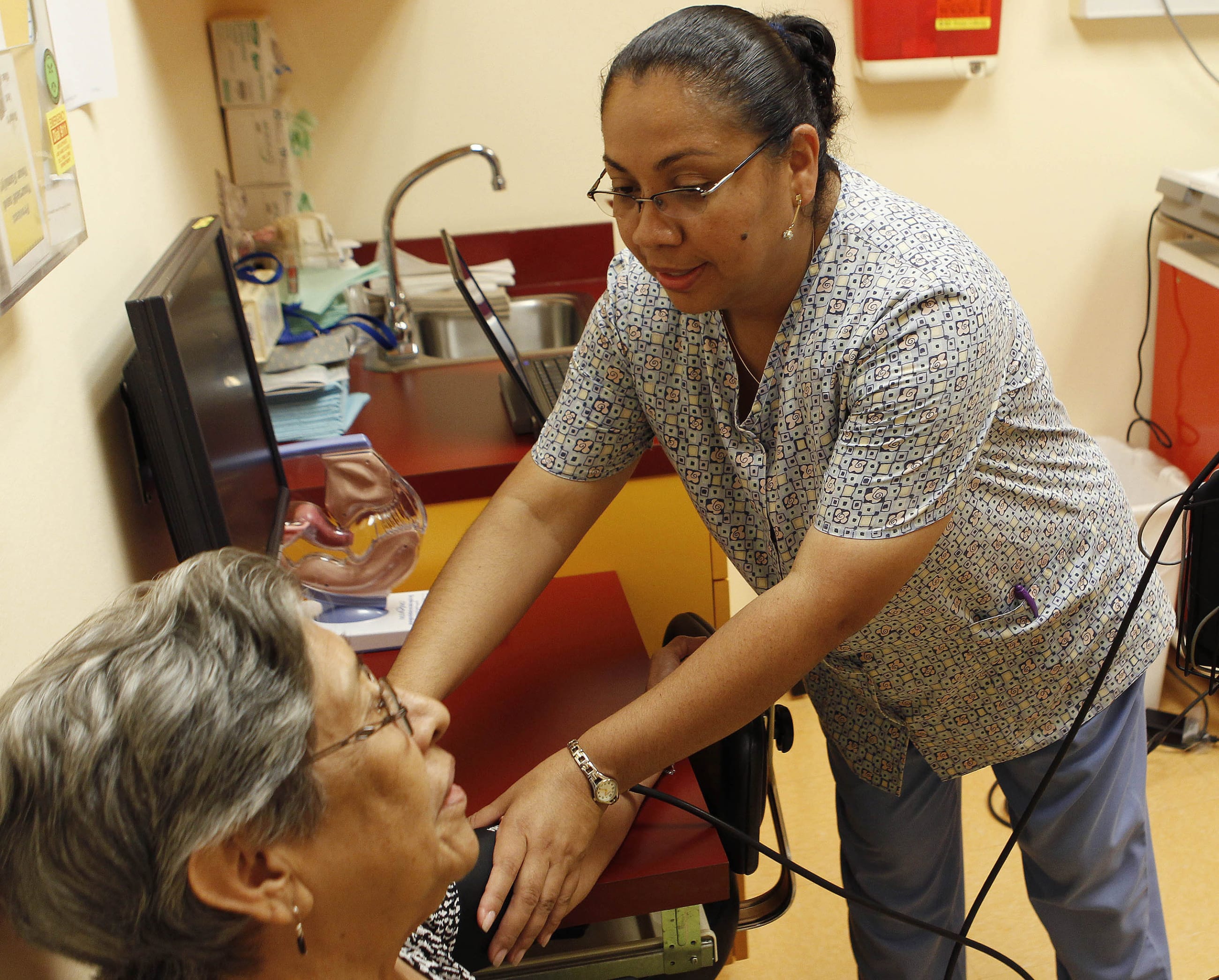 Medical assistant Maria Cortez checks the blood pressure of a patient at the La Clinica Del Pueblo community health clinic, in Washington, DC, on August 2, 2012.