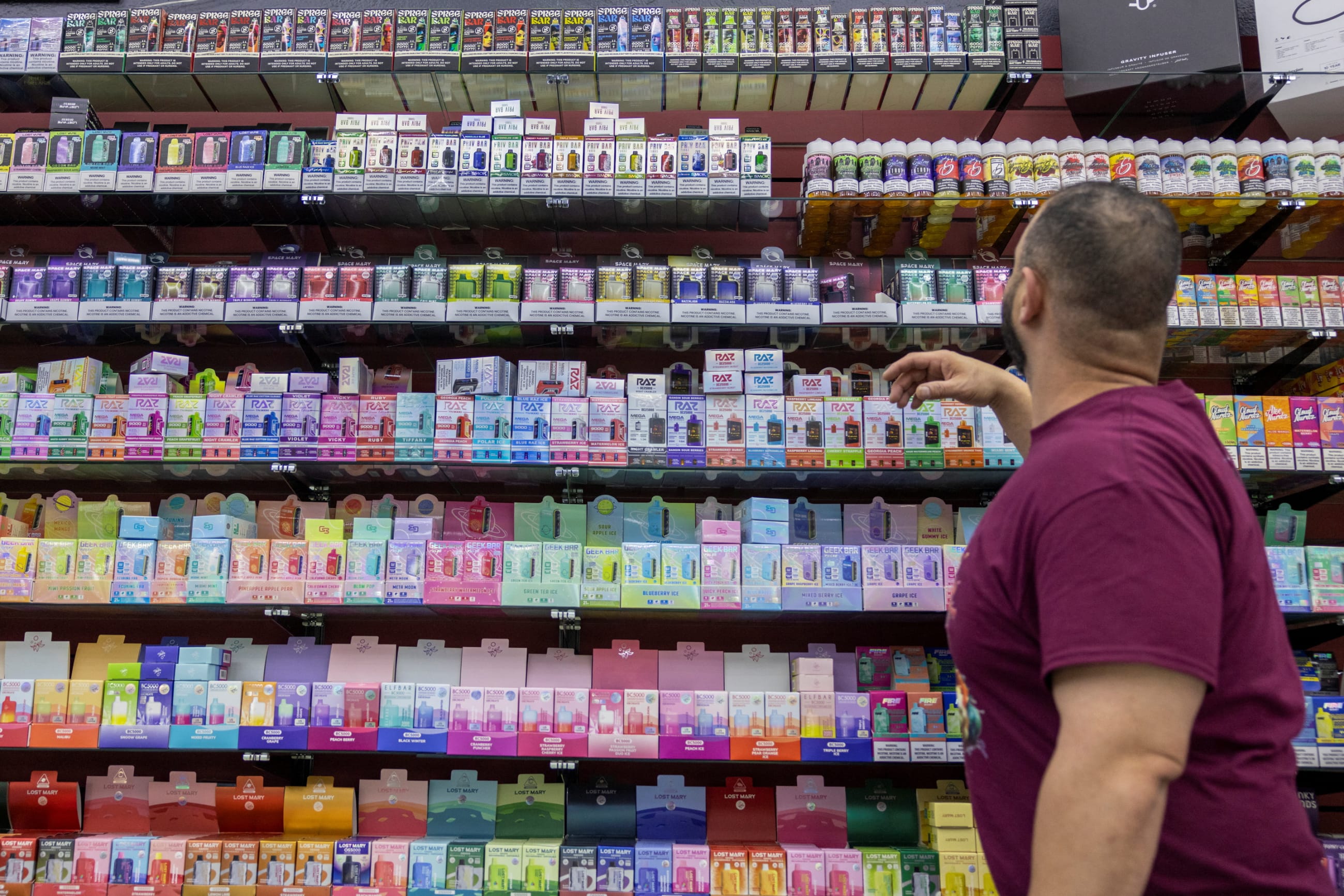 The owner of Sultans' Smoke reaches for products at his store, in Arvada, Colorado, on May 21, 2024.