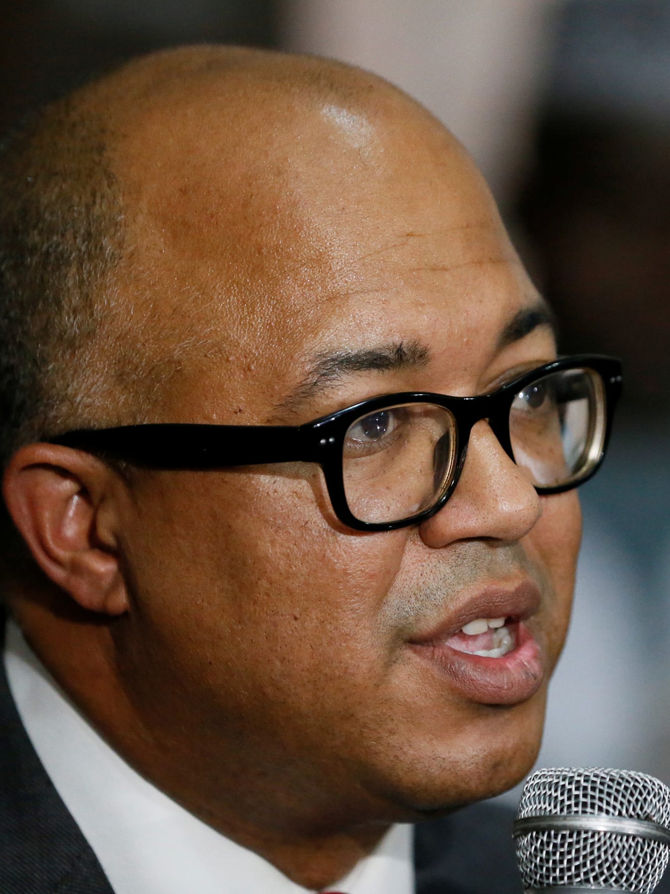 The picture shows the Director-General at a press conference speaking into a microphone.