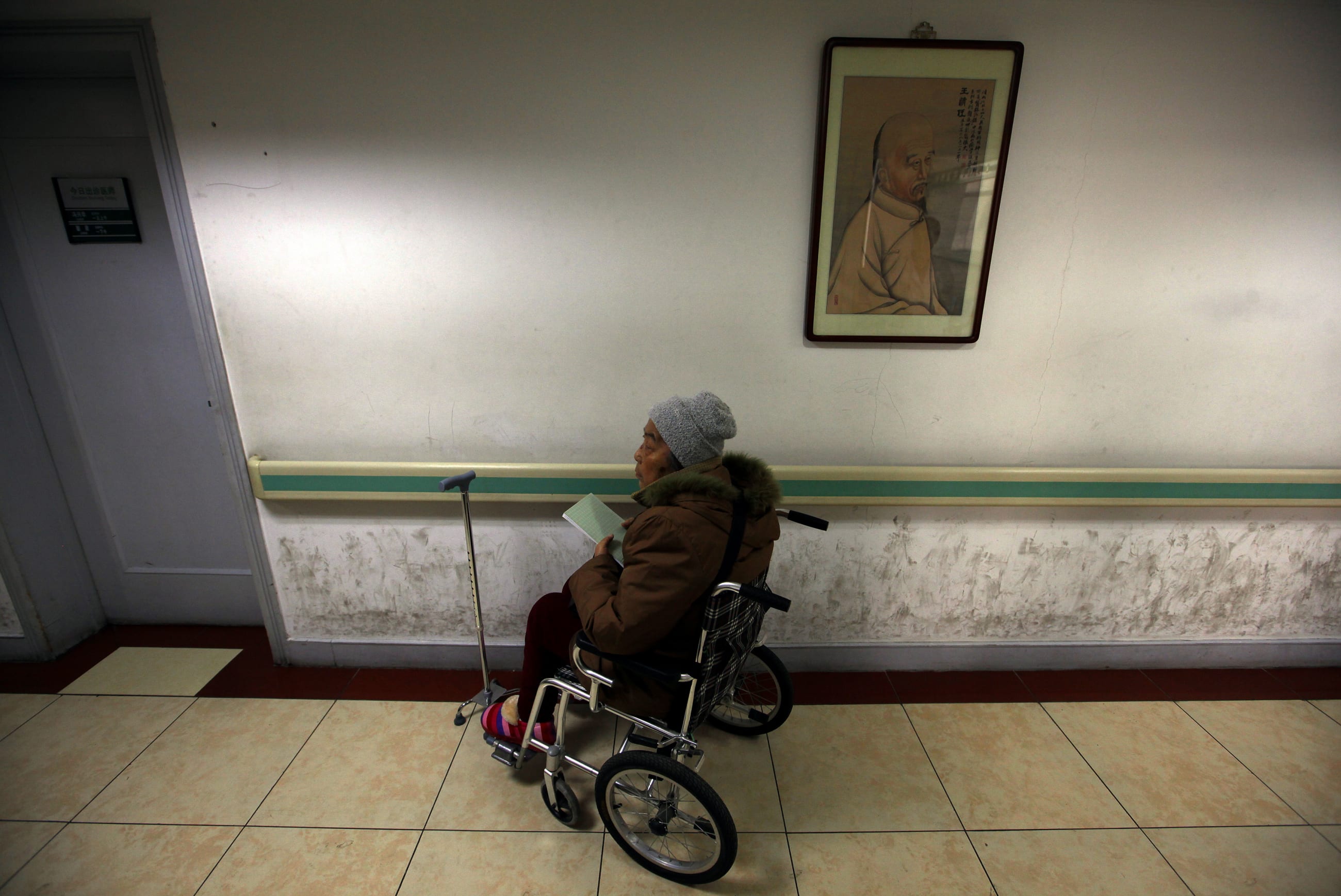 A diabetes patient sits in a wheelchair as she waits in a corridor of the Guang'anmen Hospital to see a specialist, in Beijing, China, on March 19, 2012.
