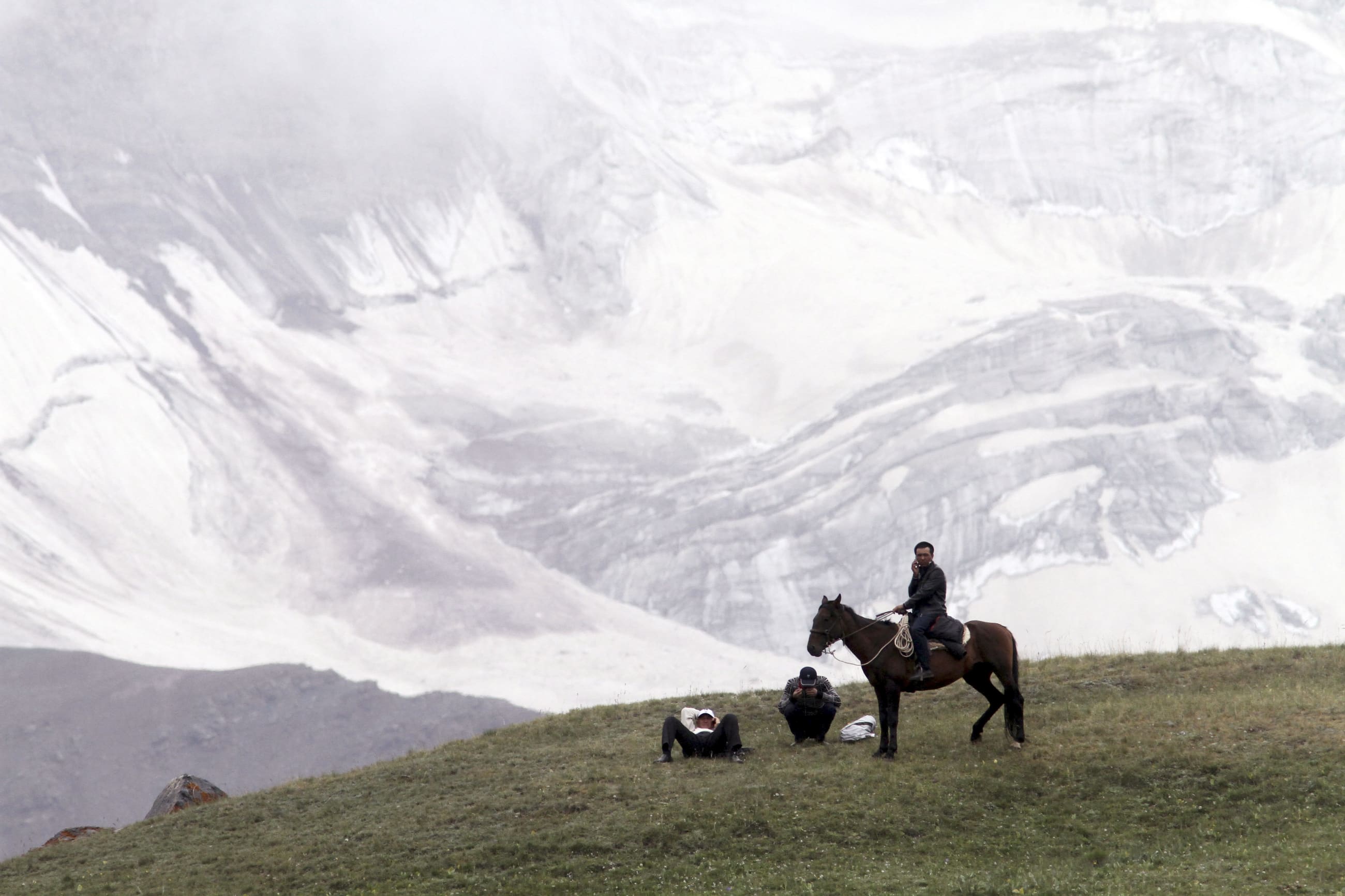 People gather before the Kyrgyz national horse games and festival, near the Tulpar-Kul lake, in the Chon Alai mountain range, in the Osh region of Kyrgyzstan, on July 25, 2015.