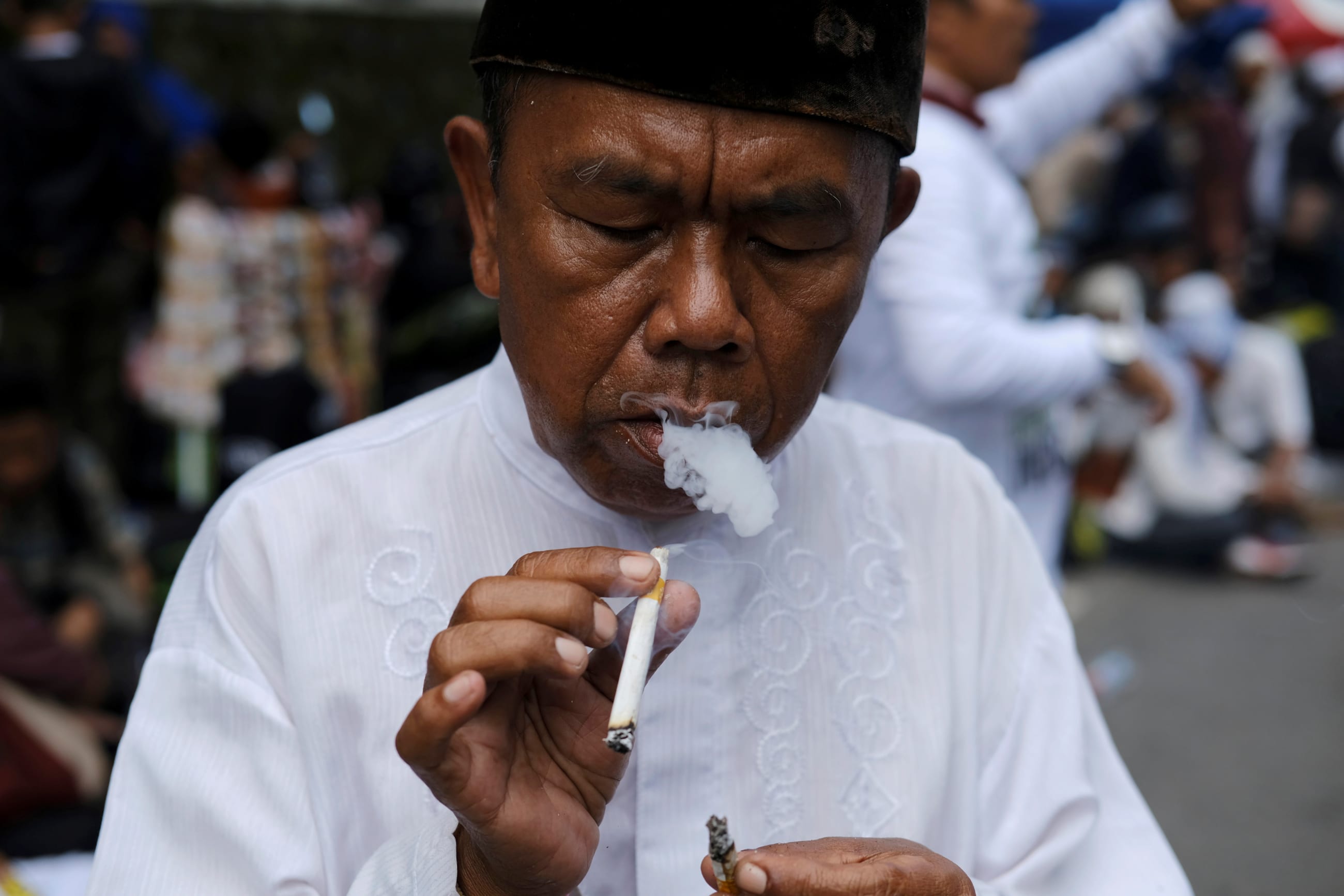 An Indonesian man smokes a cigarette during a protest near South Jakarta court, in Jakarta, Indonesia, on May 9, 2017.