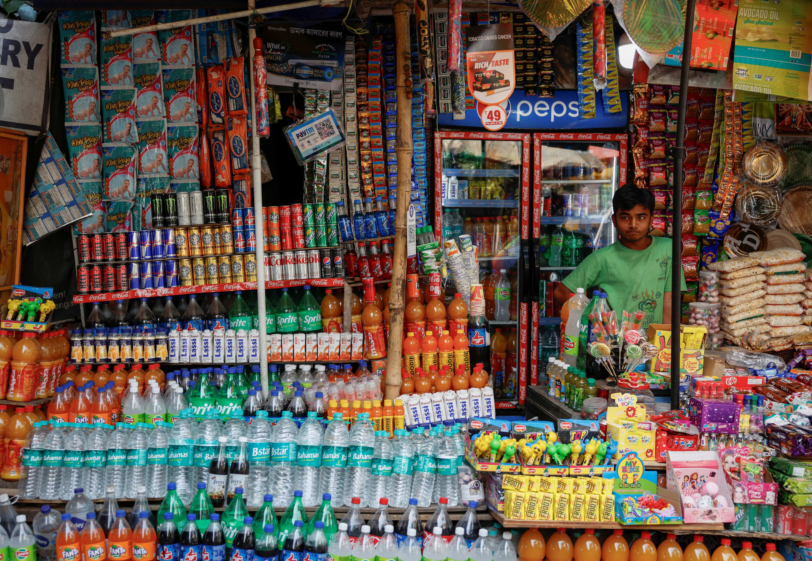 A vendor selling snacks and refreshment drinks waits for customers outside Alipore Zoological Garden, in Kolkata, India, on May 1, 2024.