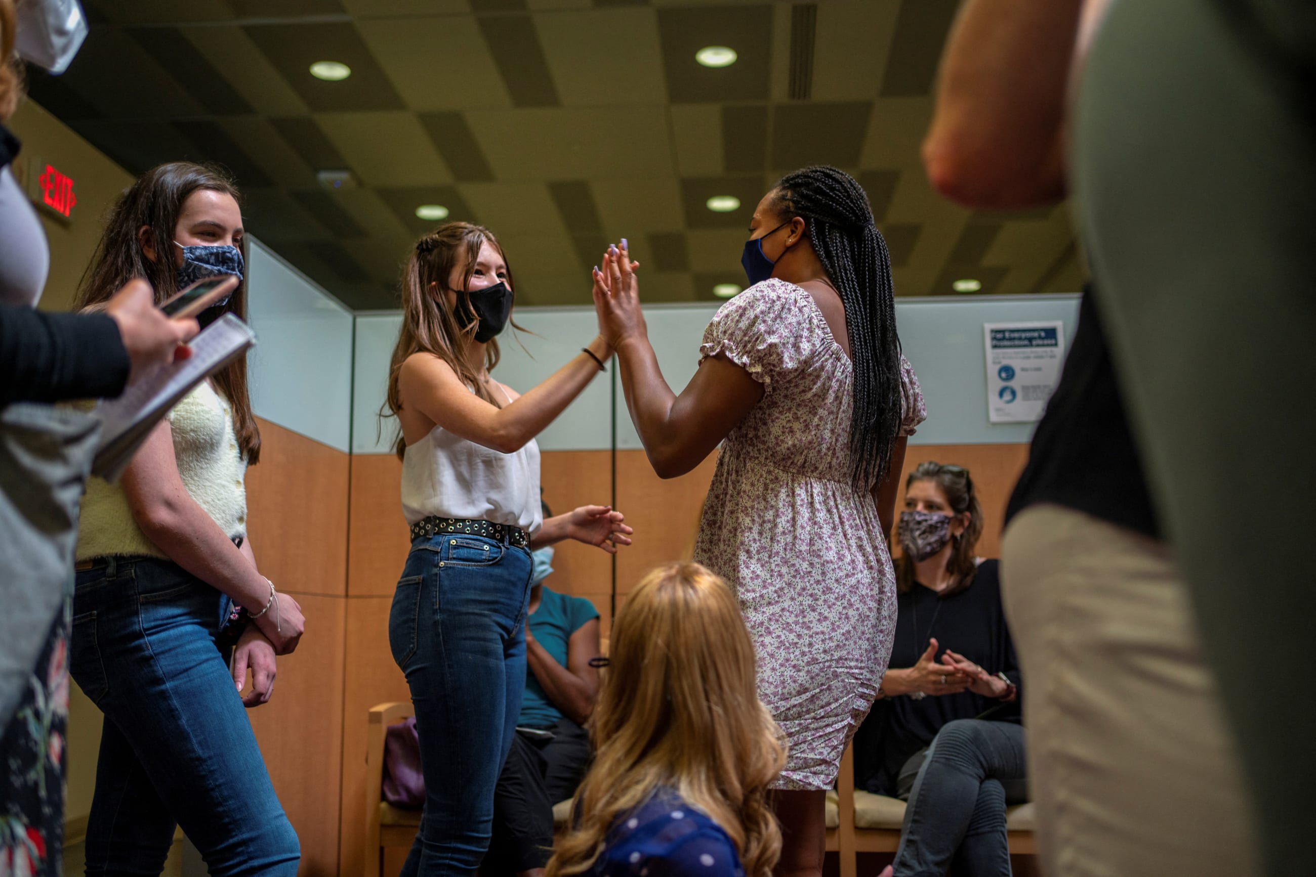 Ava Kreutziger, 14, gives Croix Hill, 15, a high five after Croix received her first dose of the COVID-19 vaccine at the Ochsner Center for Primary Care and Wellness, after the Centers for Disease Control and Prevention recommended the Pfizer vaccine for use in teenagers ages 12 to 15 in New Orleans, Louisiana, U.S., May 13, 2021. REUTERS/Kathleen Flynn