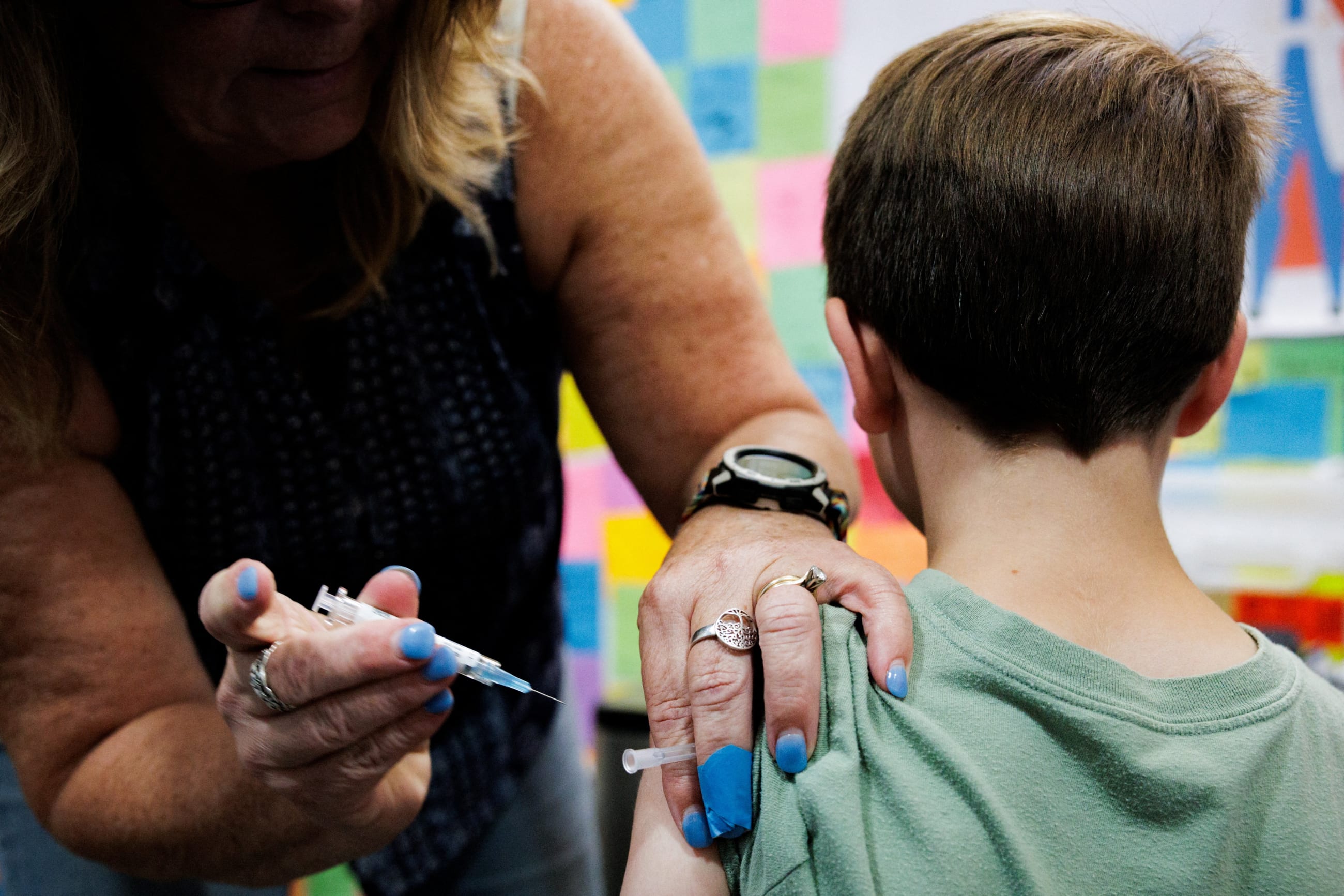 A child receives a dose of a COVID-19 vaccine at Skippack Pharmacy, in Schwenksville, Pennsylvania, on September 11, 2025.