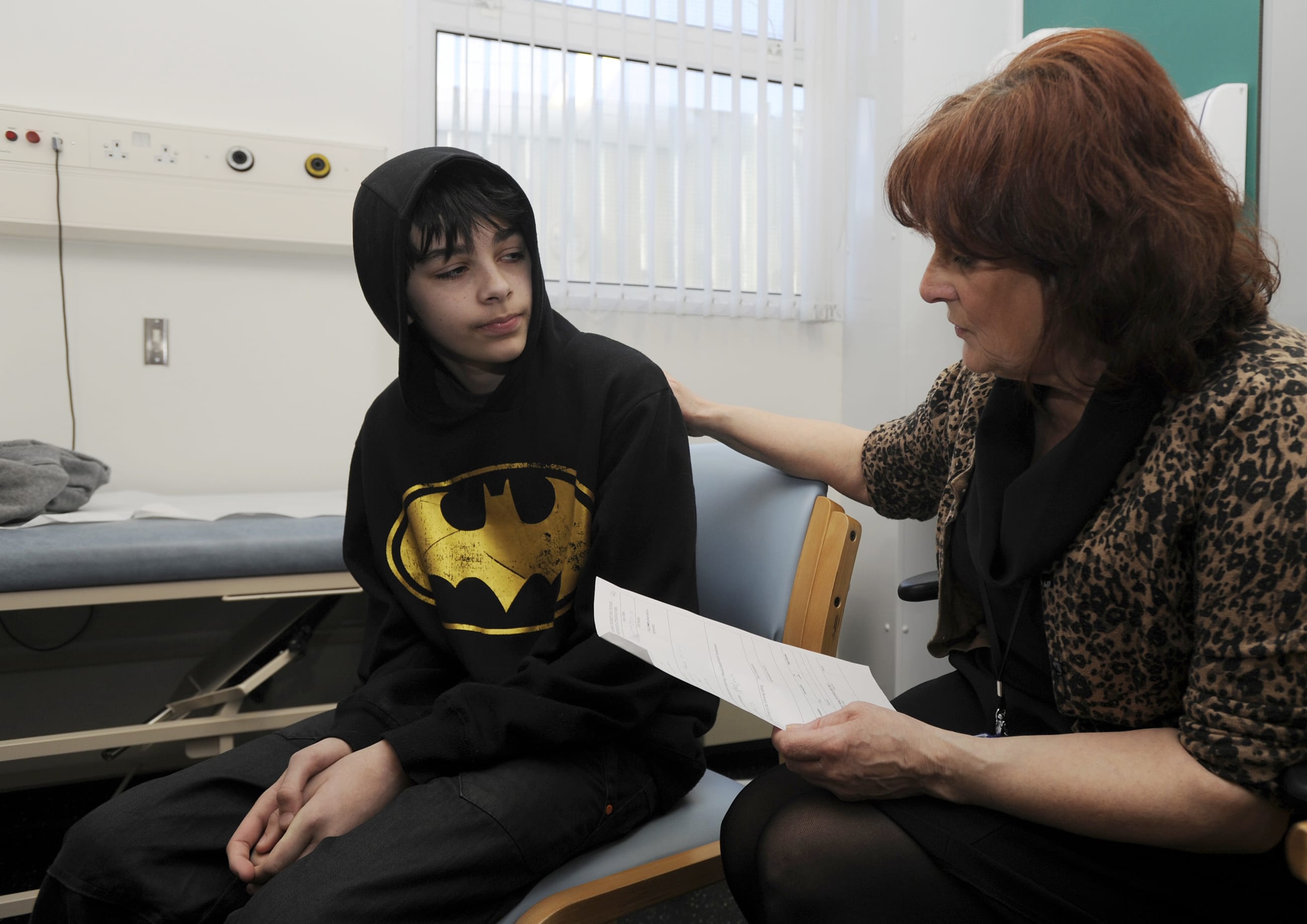School Nurse Carolyn Rees talks to Kieran Elford, aged 13, about the MMR vaccine at the pediatric outpatients department at Morriston Hospital, in Swansea, south Wales, on April 6, 2013.