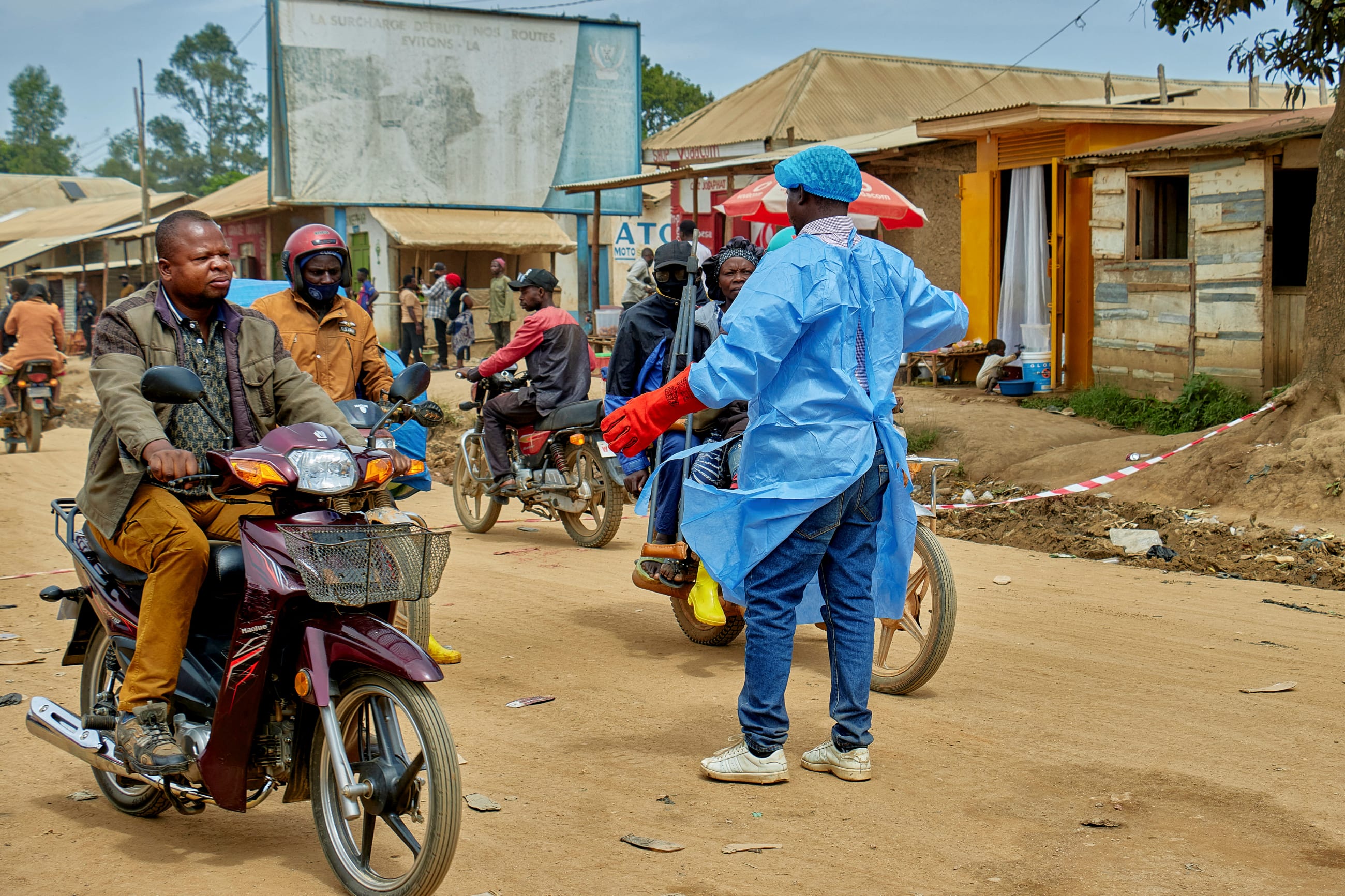 John Macki, a public health expert, controls motorcycle taxis before a health check point screening along the street, in Mongbwalu, Djugu Territory of Ituri province, Democratic Republic of the Congo, on May 23, 2026.