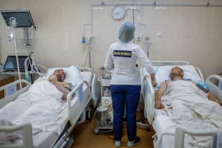 A nurse at the Mechnikov Hospital treats service members Viktor Cherniy, 52, and Vitalii Yunatskyi, 40, who were wounded during fighting against Russian forces, in an intensive care unit, in Dnipro, Ukraine, on May 14, 2025.