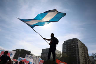 A demonstrator waves the Argentinian flag while taking part in a march to defend public universities, after Argentina's President Javier Milei vetoed laws to boost funding for pediatric hospitals and public universities, citing efforts to rein in public spending, in Buenos Aires, Argentina, on September 17, 2025.