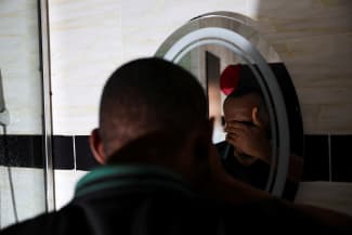 A person who contracted HIV after losing access to PrEP, washes his face, in Asaba, Delta State, Nigeria, on May 31, 2025.