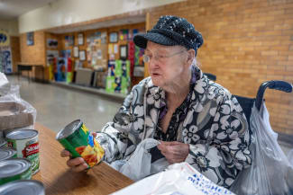 Jane Parrish, 86, collects food from a pantry supported by Trinity's Table at the Roosevelt Community Center, in Charleston, West Virginia, on March 19, 2025.