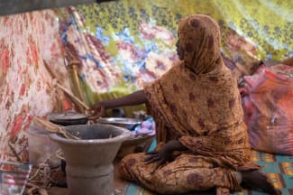 A Sudanese displaced woman who was held by the paramilitary Rapid Support Forces (RSF), cooks food at a camp for displaced people who fled from al-Fashir to Tawila, North Darfur, Sudan, on November 15, 2025.