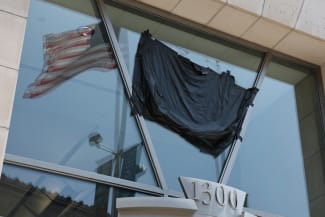 A U.S. flag is reflected in the windows of the shuttered former offices of the U.S. Agency for International Development (USAID) in Washington, DC, on July 22, 2025.