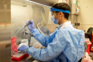 A graduate student at the Penn Center for Research on Coronavirus and Other Emerging Pathogens, demonstrates a viral RNA extraction at the University of Pennsylvania’s Perelman School of Medicine, in Philadelphia, Pennsylvania, on December 16, 2021
