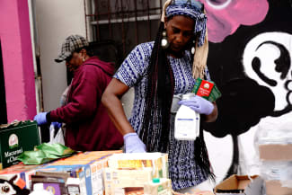 A volunteer grips bottles of Similac baby formula while preparing aid packages for people experiencing food insecurity at a give-away of food and baby formula held by the San Diego Original Black Panther Party for Community Empowerment, in San Diego, California, on May 25, 2022.