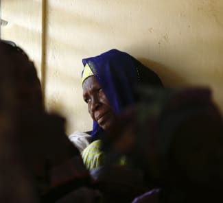 A woman gazes out of a window while attending a talk on sexual health and HIV prevention, in the Tanghin neighborhood of Ouagadougou, Burkina Faso, on April 13, 2013.