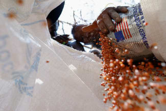 A woman from the indigenous Turkana Nilotic community pours sorghum grains into a sack, at a World Food Program food distribution center, at the Kenya Oil village near Lodwar, in Turkana County, Kenya, on February 17, 2026.
