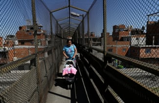 A woman pushes a baby stroller, in Villa Soldati, Argentina, on September 16, 2024.