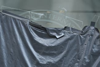 Plastic peels back to reveal the covered logo on the windows of the shuttered offices of the U.S. Agency for International Development, in Washington, DC, on July 22, 2025.