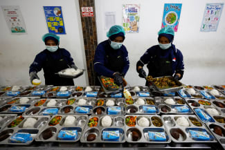 Workers prepare meals to be distributed free for students, during the free nutritious meals program trial, at a pilot kitchen in Sukabumi, West Java province, Indonesia, September 25, 2024.