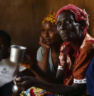 HIV-positive members of a self-help group meet with a caregiver in the village of Michelo, Zambia, on February 23, 2015.