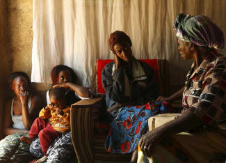 A home-based caregiver visits an HIV/AIDS patient in her home in Matero township, Lusaka, Zambia, on April 17, 2012.
