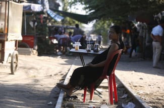 A pregnant woman rests on the railway track in front of her home, in Phnom Penh, Cambodia, on February 4, 2016.