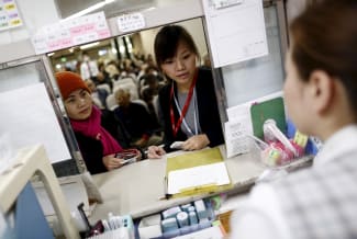 Dang Nguyen Thuc Vien, a 32-year-old daughter of refugees from south Vietnam, helps a local Vietnamese resident in Japan as an interpreter at a hospital, in Kanagawa prefecture, Japan, on November 25, 2015.
