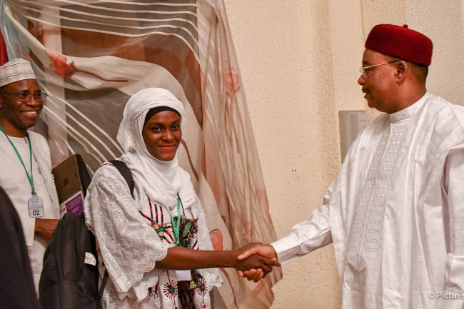Helping youth directly address their leaders: Mariam Abou Gado, Ouagadougou Partnership Youth Ambassador in Niger, meets with President Issoufou of Niger to discuss recommendations on family planning. The photo shows a smiling Miriam shaking hands with the president. PHOTO courtesy of EtriLabs/Yves Tamomo