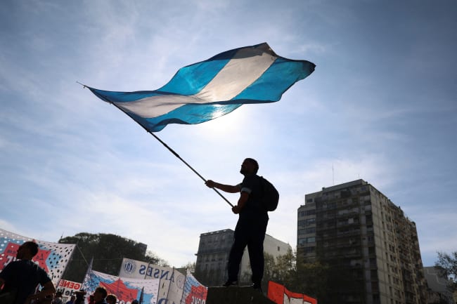 A demonstrator waves the Argentinian flag while taking part in a march to defend public universities, after Argentina's President Javier Milei vetoed laws to boost funding for pediatric hospitals and public universities, citing efforts to rein in public spending, in Buenos Aires, Argentina, on September 17, 2025.