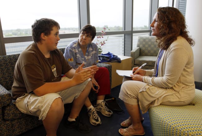 Micah Peterson, 15, and his mother talk with Marilyn Day, director of a child and teen weight management program, during a counseling session at The Children's Hospital, in Aurora, Colorado, on July 8, 2010.