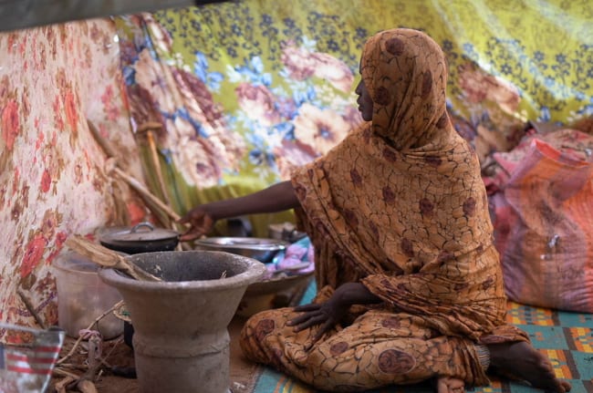 A Sudanese displaced woman who was held by the paramilitary Rapid Support Forces (RSF), cooks food at a camp for displaced people who fled from al-Fashir to Tawila, North Darfur, Sudan, on November 15, 2025.