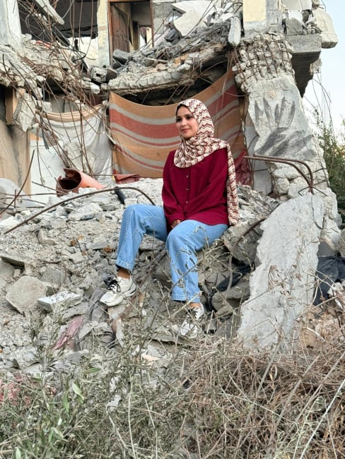 Project HOPE Gaza Human Resources Coordinator Nouralhuda Abu Gefra sits in the rubble of her partially damaged house in Gaza, on October 14, 2025.
